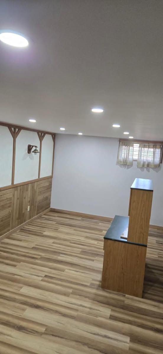 Finished basement living area with recessed pot lighting