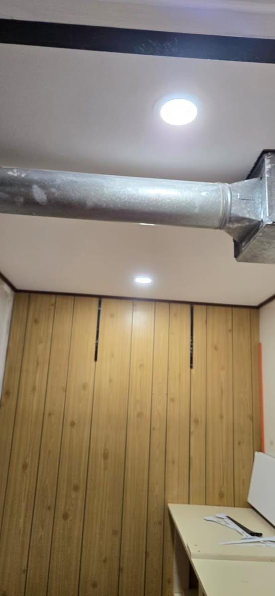 Wood-paneled feature wall with ceiling pot lighting