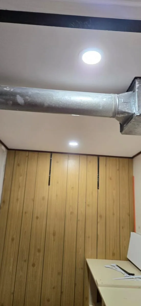 Wood paneled feature wall lit by ceiling pot lights